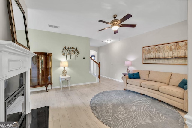 3982 Brockenhurst Dr, Buford, GA 30519 - living area featuring wood finished floors, a ceiling fan, a fireplace, baseboards, and stairs