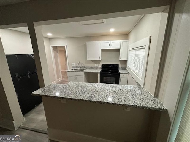 747 Harrold, Macon, GA 31201 - kitchen featuring black / electric stove, a sink, light stone countertops, a kitchen bar, and recessed lighting