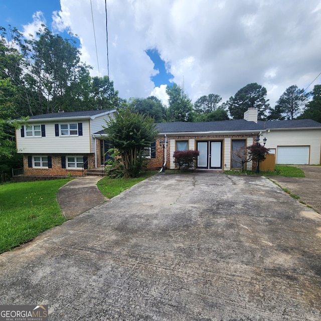 3140 Kipling Dr, Powder Springs, GA 30127 - split level home featuring driveway, brick siding, a chimney, a front yard, and a garage