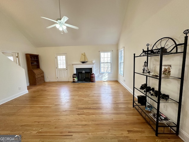 119 E Surry Ct, Athens, GA 30606 - unfurnished living room with high vaulted ceiling, a ceiling fan, a fireplace with flush hearth, light wood-type flooring, and baseboards
