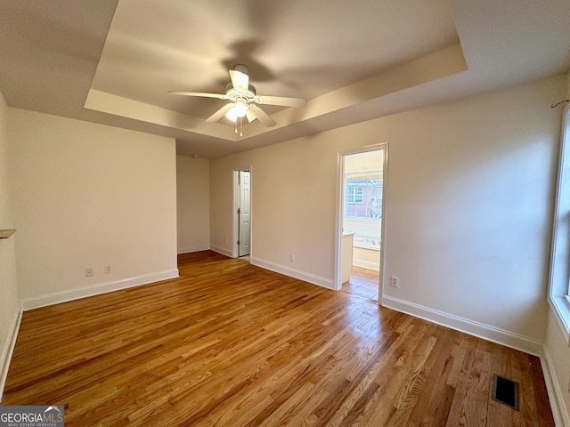 119 E Surry Ct, Athens, GA 30606 - empty room with a tray ceiling, ceiling fan, light wood-style floors, and baseboards