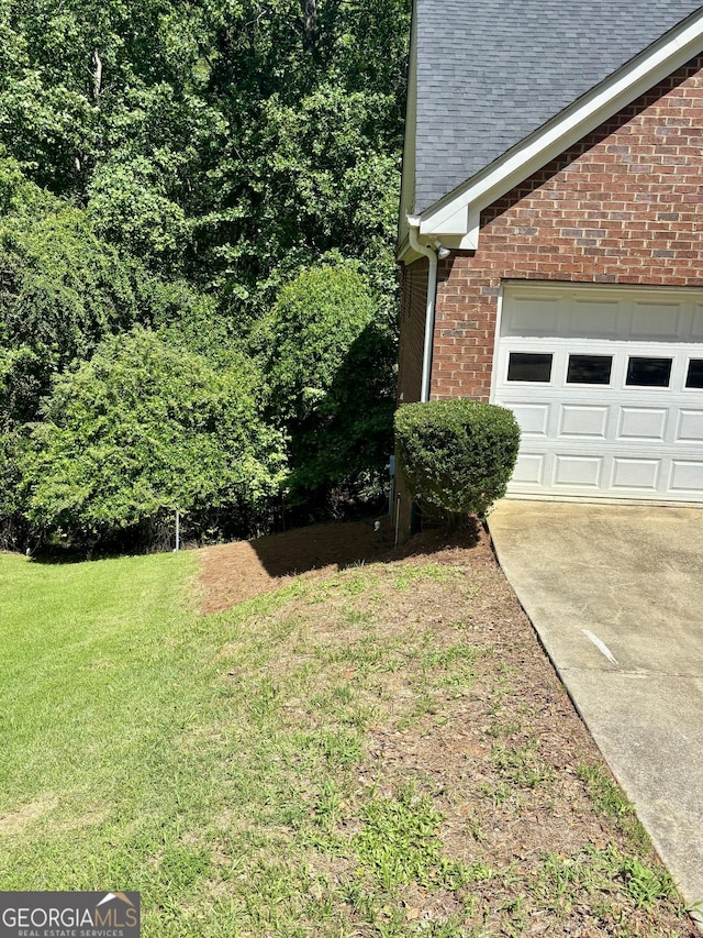 119 E Surry Ct, Athens, GA 30606 - view of home's exterior featuring brick siding, a yard, roof with shingles, and driveway