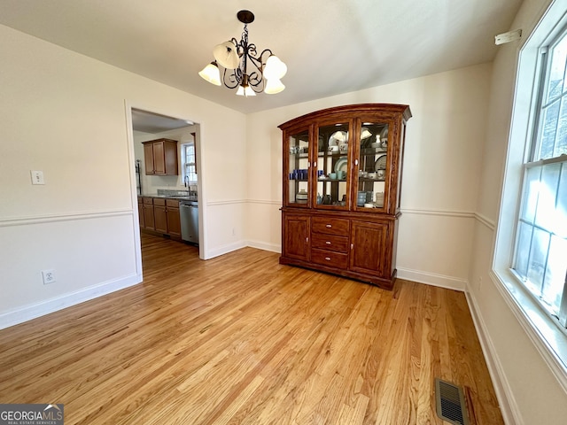 119 E Surry Ct, Athens, GA 30606 - unfurnished dining area featuring a chandelier, light wood-type flooring, and healthy amount of natural light