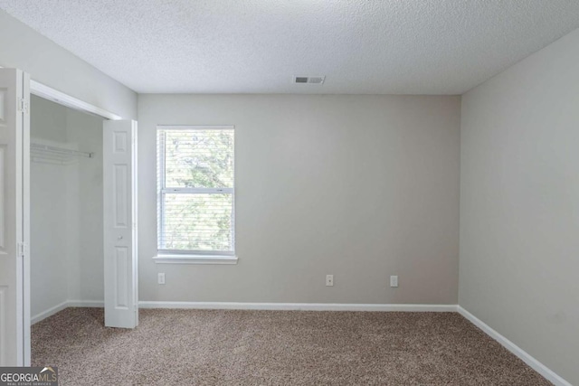 7250 Old Chapel, Atlanta, GA 30349 - unfurnished bedroom featuring carpet floors, a textured ceiling, and a closet