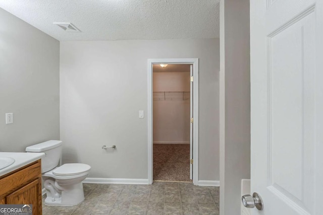 7250 Old Chapel, Atlanta, GA 30349 - bathroom with vanity, a textured ceiling, and a spacious closet