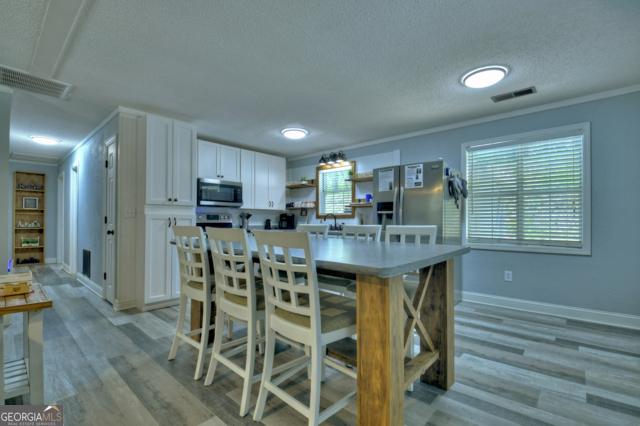 151 Padget Ln, Ellijay, GA 30540 - kitchen featuring appliances with stainless steel finishes, white cabinetry, open shelves, crown molding, and light wood finished floors
