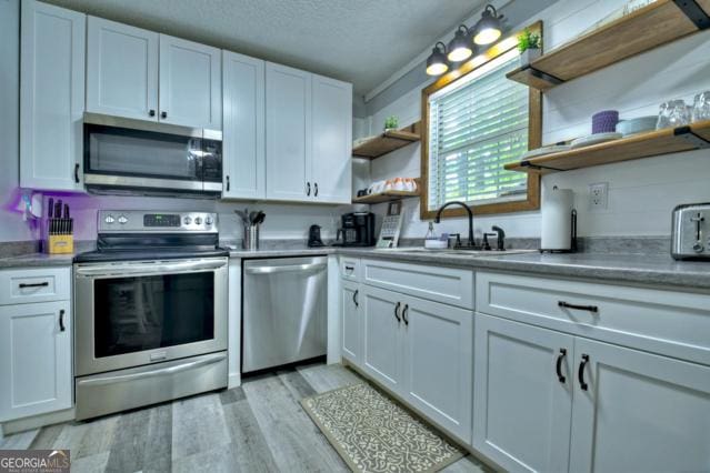 151 Padget Ln, Ellijay, GA 30540 - kitchen featuring open shelves, appliances with stainless steel finishes, a sink, white cabinets, and a textured ceiling