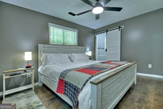 151 Padget Ln, Ellijay, GA 30540 - bedroom with wood finished floors, baseboards, a barn door, and a ceiling fan