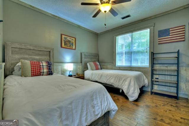 151 Padget Ln, Ellijay, GA 30540 - bedroom featuring wood-type flooring, a textured ceiling, and a ceiling fan