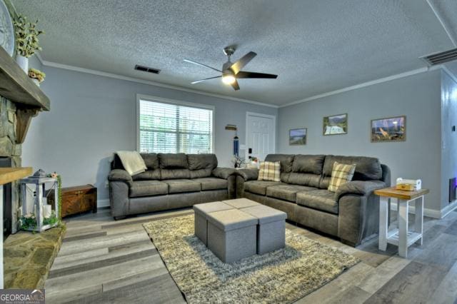 151 Padget Ln, Ellijay, GA 30540 - living room featuring a ceiling fan, a textured ceiling, ornamental molding, light wood-style floors, and baseboards