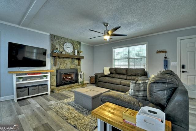 151 Padget Ln, Ellijay, GA 30540 - living room with a ceiling fan, wood finished floors, a fireplace, ornamental molding, and a textured ceiling