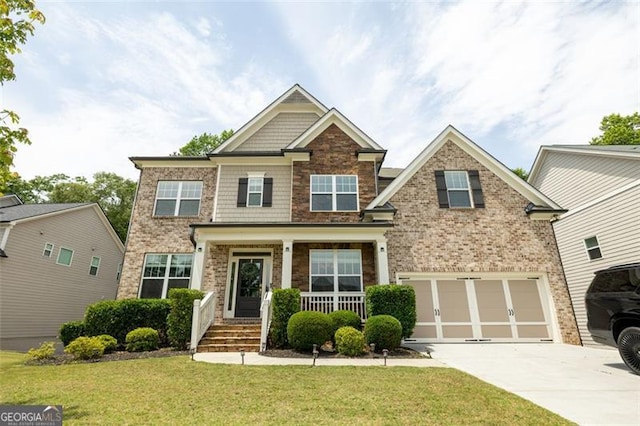 3589 Tamerton Trce, Buford, GA 30519 - craftsman inspired home featuring driveway, a front lawn, covered porch, an attached garage, and brick siding