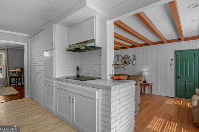 1504 Danora Dr, Waycross, GA 31501 - kitchen featuring under cabinet range hood, black electric cooktop, tile countertops, light wood finished floors, and beamed ceiling