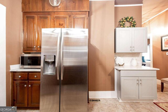 791 E Main St, Canton, GA 30114 - kitchen with appliances with stainless steel finishes, light countertops, decorative backsplash, and brown cabinetry
