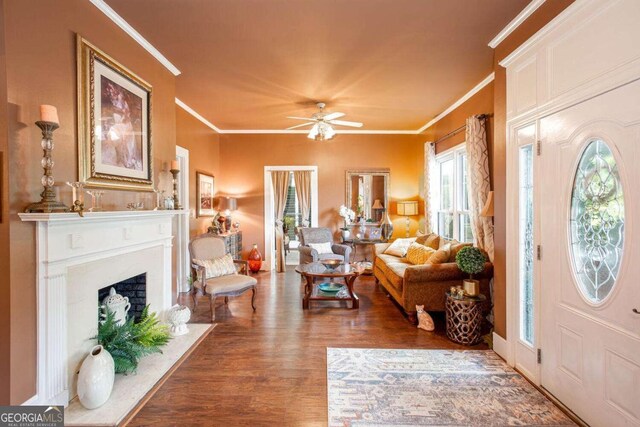 791 E Main St, Canton, GA 30114 - entryway featuring wood finished floors, ornamental molding, ceiling fan, and a fireplace with flush hearth