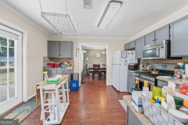 850 Long Branch Cir, Sugar Hill, GA 30518 - kitchen featuring appliances with stainless steel finishes, gray cabinets, dark wood-style flooring, decorative backsplash, and ornamental molding