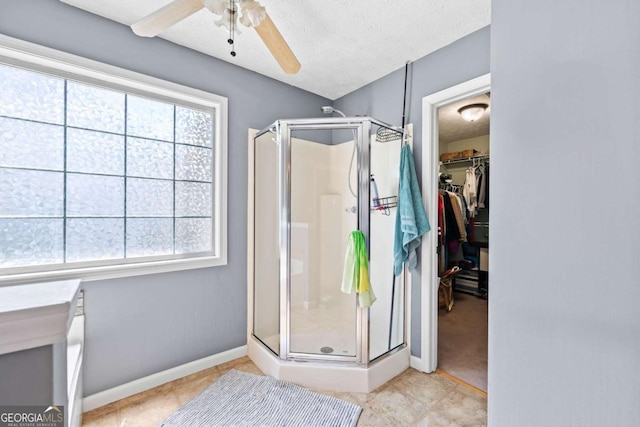 850 Long Branch Cir, Sugar Hill, GA 30518 - bathroom with a shower stall, plenty of natural light, a walk in closet, and a textured ceiling