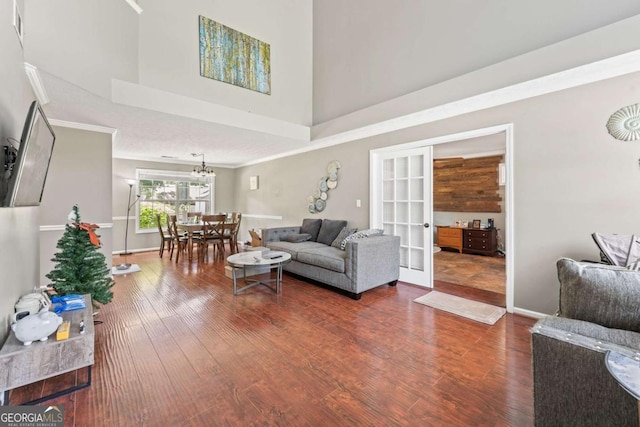 850 Long Branch Cir, Sugar Hill, GA 30518 - living room featuring wood finished floors, a high ceiling, french doors, crown molding, and a chandelier