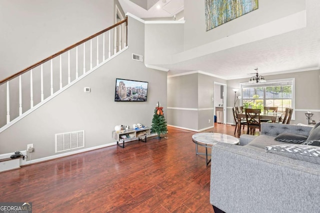 850 Long Branch Cir, Sugar Hill, GA 30518 - living room featuring ornamental molding, a high ceiling, stairs, a chandelier, and wood finished floors