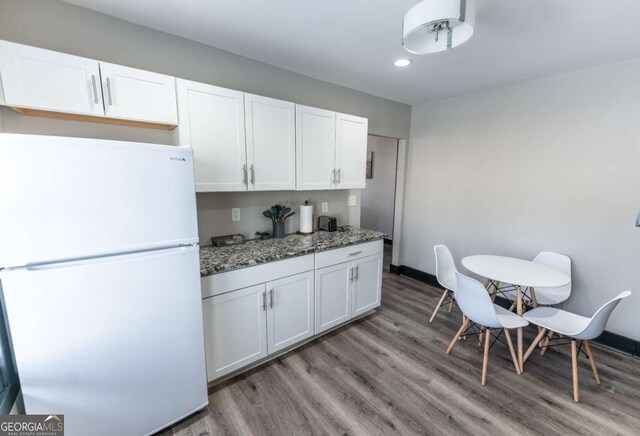 1764 Spring Ave, East Point, GA 30344 - kitchen with freestanding refrigerator, white cabinets, recessed lighting, light wood finished floors, and stone countertops