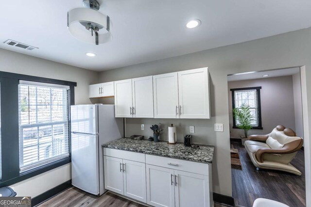 1764 Spring Ave, East Point, GA 30344 - kitchen with freestanding refrigerator, wood finished floors, white cabinetry, plenty of natural light, and recessed lighting