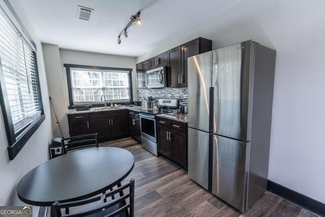 1764 Spring Ave, East Point, GA 30344 - kitchen with stainless steel appliances, dark wood-style flooring, decorative backsplash, and light stone counters
