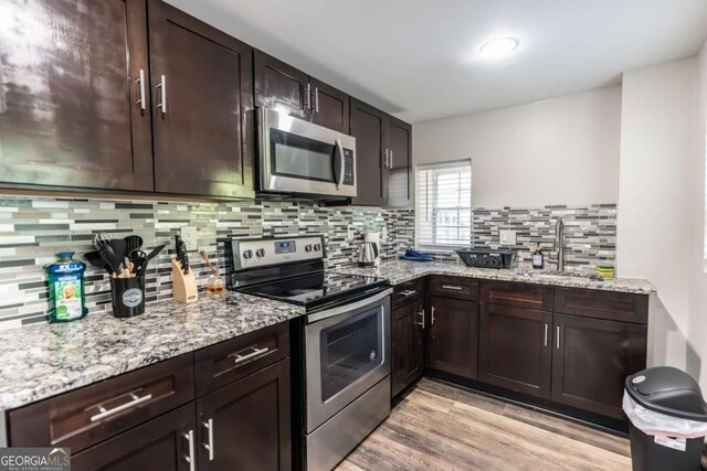 1764 Spring Ave, East Point, GA 30344 - kitchen featuring stainless steel appliances, tasteful backsplash, light stone counters, and dark brown cabinets