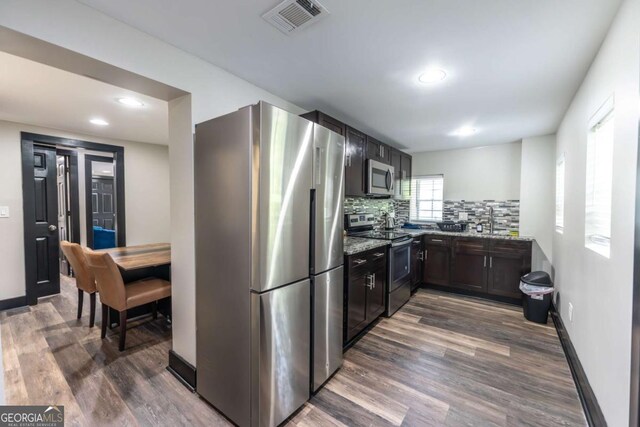 1764 Spring Ave, East Point, GA 30344 - kitchen with stainless steel appliances, dark wood-style floors, decorative backsplash, light stone countertops, and recessed lighting