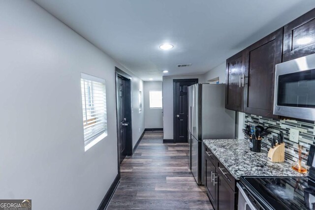1764 Spring Ave, East Point, GA 30344 - kitchen with stainless steel appliances, dark wood-style flooring, light stone counters, decorative backsplash, and dark brown cabinets