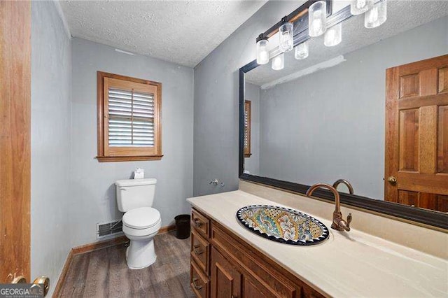 2041 Millspring Way NW, Kennesaw, GA 30152 - half bathroom with wood finished floors, toilet, a textured ceiling, vanity, and baseboards