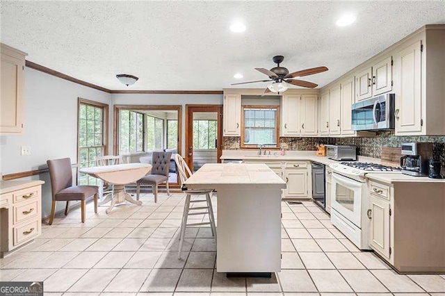 2041 Millspring Way NW, Kennesaw, GA 30152 - kitchen featuring stainless steel microwave, white range with gas stovetop, a sink, light countertops, and a textured ceiling