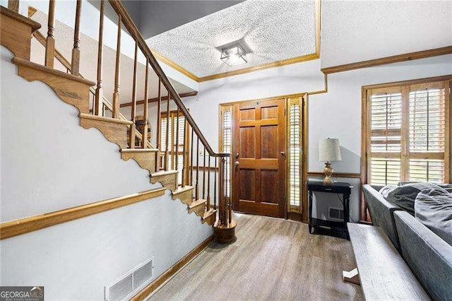 2041 Millspring Way NW, Kennesaw, GA 30152 - foyer entrance featuring wood finished floors, stairs, baseboards, a textured ceiling, and crown molding