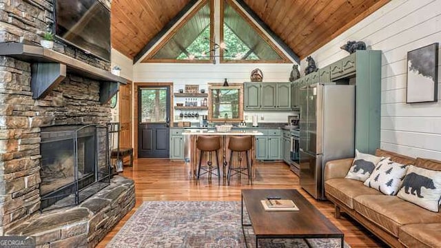 437 Spruce Cir Unit G, Mineral Bluff, GA 30559 - living area with wood ceiling, light wood-type flooring, a stone fireplace, lofted ceiling, and wood walls