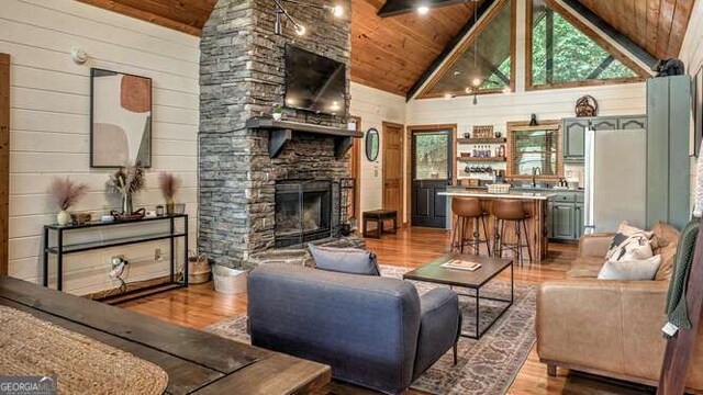 437 Spruce Cir Unit G, Mineral Bluff, GA 30559 - living area with wooden ceiling, light wood-style floors, a fireplace, high vaulted ceiling, and wood walls