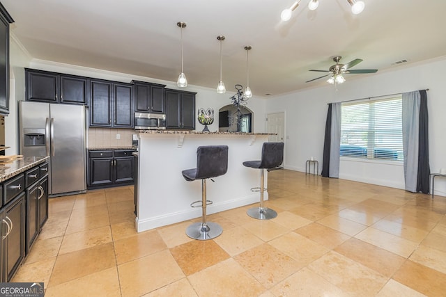 2689 Muskeg Ct SW, South Fulton, GA 30331 - kitchen with appliances with stainless steel finishes, a kitchen breakfast bar, tasteful backsplash, a ceiling fan, and ornamental molding