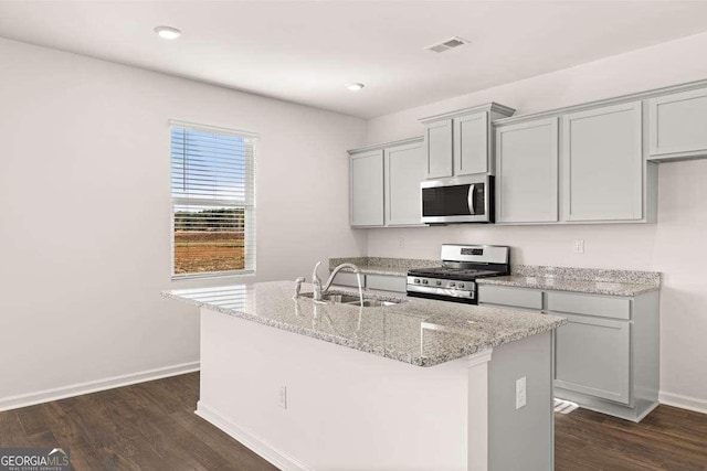 170 Aster Ave, Locust Grove, GA 30248 - kitchen featuring stainless steel appliances, a sink, baseboards, light stone countertops, and dark wood-type flooring