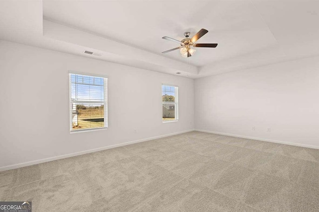 170 Aster Ave, Locust Grove, GA 30248 - carpeted empty room with a tray ceiling, ceiling fan, plenty of natural light, and baseboards