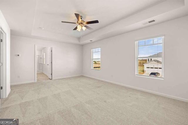 170 Aster Ave, Locust Grove, GA 30248 - unfurnished bedroom with a tray ceiling, baseboards, carpet flooring, ensuite bathroom, and ceiling fan