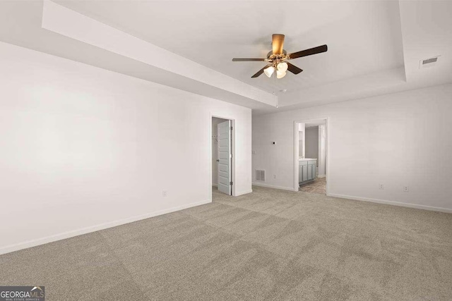 170 Aster Ave, Locust Grove, GA 30248 - unfurnished room featuring a raised ceiling, baseboards, ceiling fan, and light colored carpet