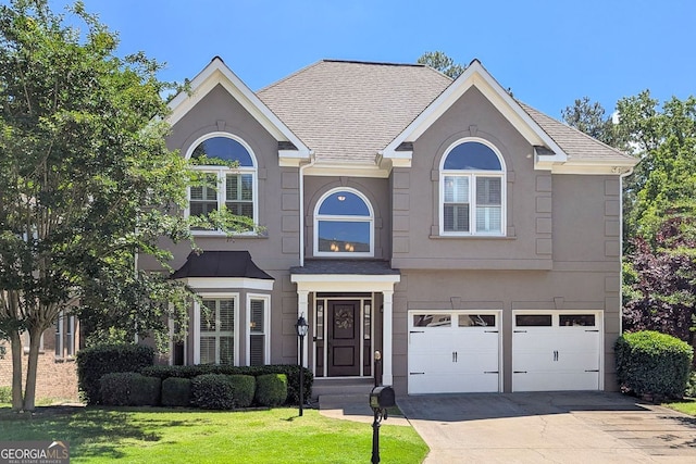 4527 Village Springs Run, Dunwoody, GA 30338 - view of front facade featuring a garage, stucco siding, driveway, a front lawn, and roof with shingles