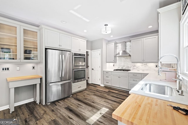 4527 Village Springs Run, Dunwoody, GA 30338 - kitchen featuring stainless steel appliances, wall chimney exhaust hood, a sink, recessed lighting, and backsplash