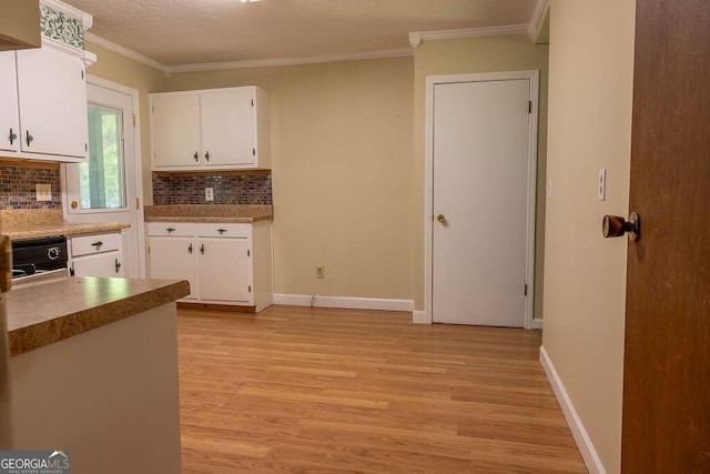 4370 Tradition Ter, Austell, GA 30106 - kitchen with light wood-style floors, tasteful backsplash, white cabinets, ornamental molding, and baseboards