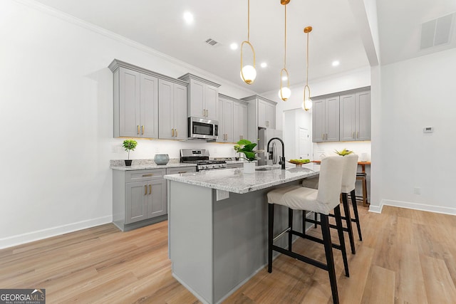 8544 Plumtree Dr, Riverdale, GA 30274 - kitchen with gray cabinetry, stainless steel appliances, a sink, a kitchen breakfast bar, and a kitchen island with sink