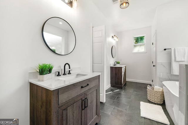 8544 Plumtree Dr, Riverdale, GA 30274 - bathroom with two vanities, a soaking tub, and baseboards