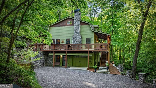 744 Dover Falls Trl, Ellijay, GA 30540 - view of front facade with gravel driveway, a deck, stairway, a chimney, and a garage