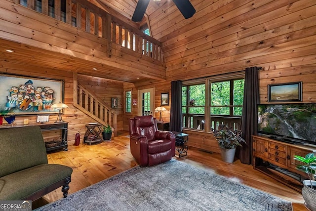 744 Dover Falls Trl, Ellijay, GA 30540 - living area featuring hardwood / wood-style floors, wood walls, stairs, ceiling fan, and a high ceiling