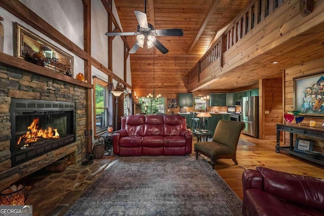 744 Dover Falls Trl, Ellijay, GA 30540 - living area featuring a stone fireplace, a towering ceiling, wooden walls, a ceiling fan, and light wood finished floors