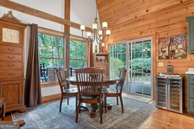 744 Dover Falls Trl, Ellijay, GA 30540 - dining area featuring beverage cooler, wood walls, plenty of natural light, a chandelier, and light wood-type flooring