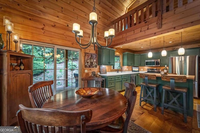 744 Dover Falls Trl, Ellijay, GA 30540 - dining space featuring wood finished floors, plenty of natural light, a chandelier, wooden walls, and a towering ceiling
