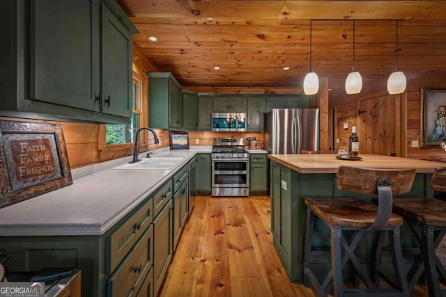 744 Dover Falls Trl, Ellijay, GA 30540 - kitchen featuring green cabinetry, stainless steel appliances, a sink, light wood-style floors, and a breakfast bar